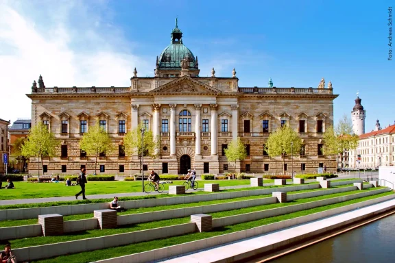 Die eindrucksvolle Außenfassade des Bundesverwaltungsgerichts mit Grünanlage und Passanten.