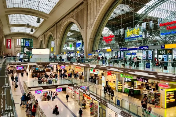 Blick in die Querhalle des Hauptbahnhofs mit Geschäften der Bahnhofspromenade.