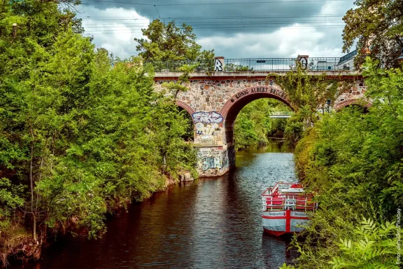 Der sommerliche Karl-Heine-Kanal mit König-Albert-Brücke und Boot.