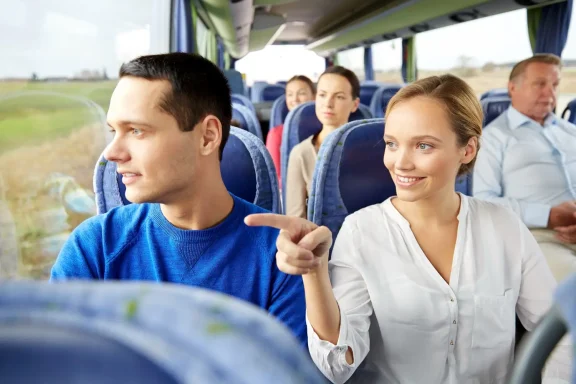 Gutgelaunte Gäste in einem Reisebus genießen eine Stadtrundfahrt.