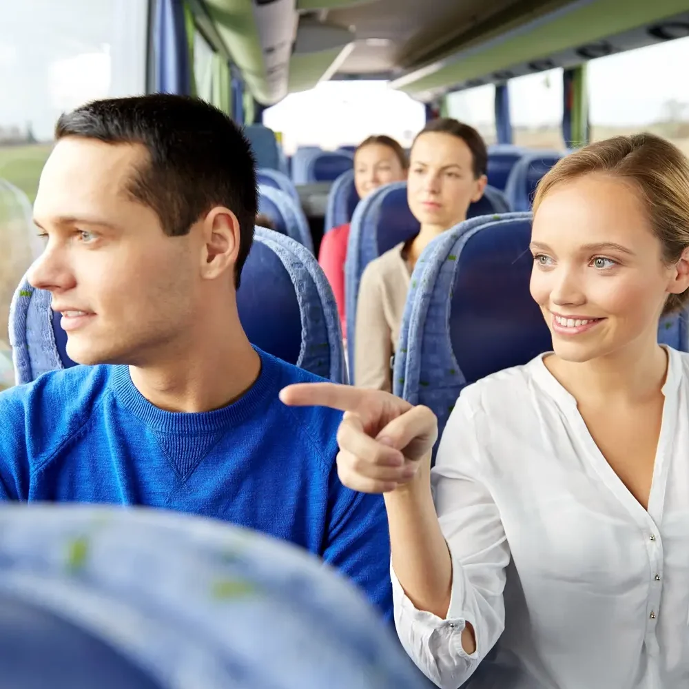 Lächelnde Fahrgäste in einem Reisebus.