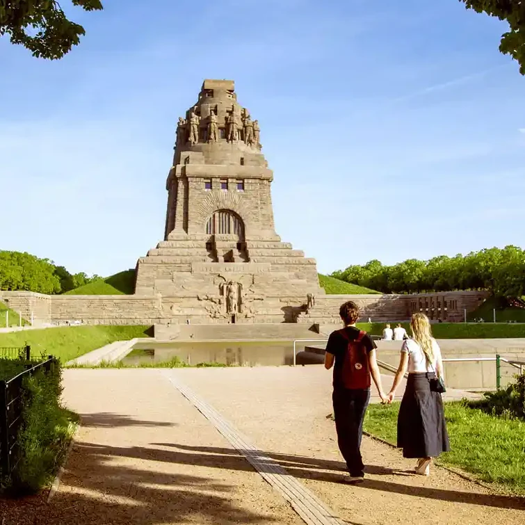 Das Völkerschlachtdenkmal mit Passanten im Abendlicht.