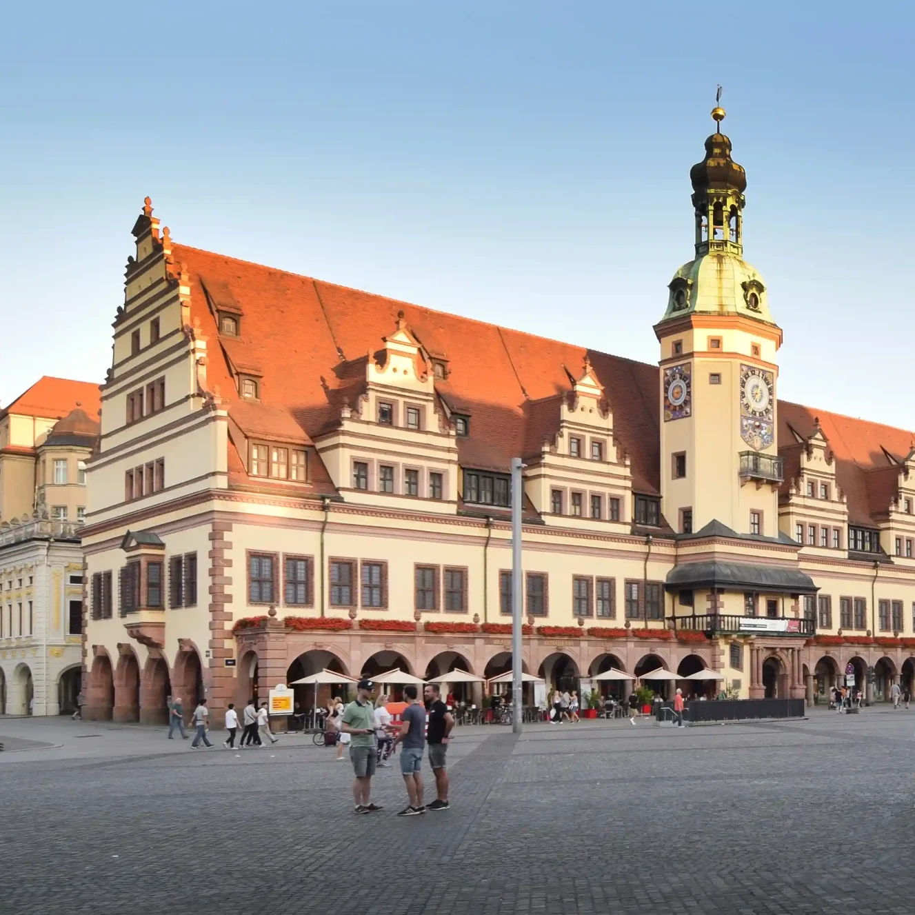 Das Alte Rathaus mit Passanten im Abendlicht.