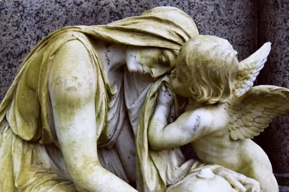 Detail einer historischen Grabfigur aus verwittertem Marmor.